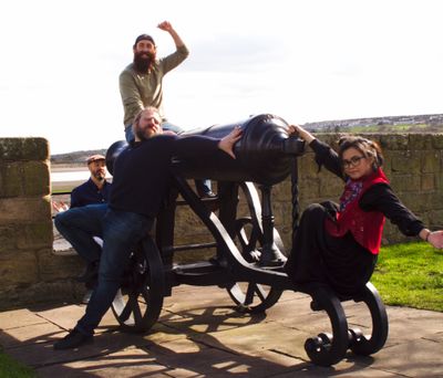 The four band members draped over a canon!